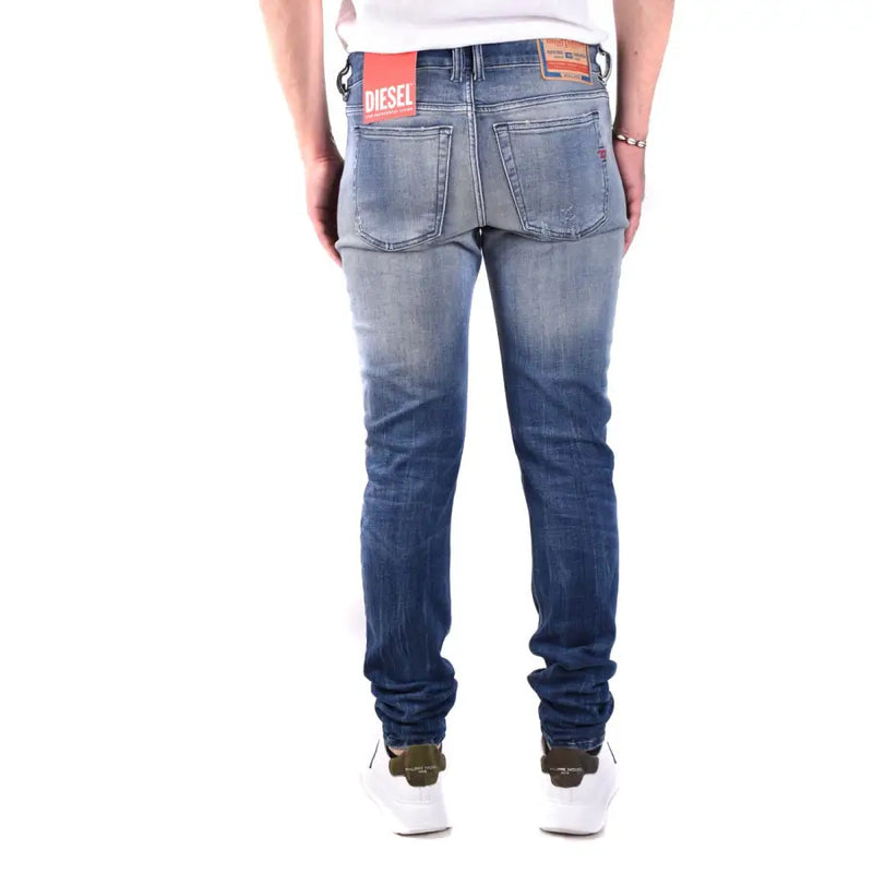 Blue cotton diesel men jeans with worn effect faded wash and distressed details shown from the back side