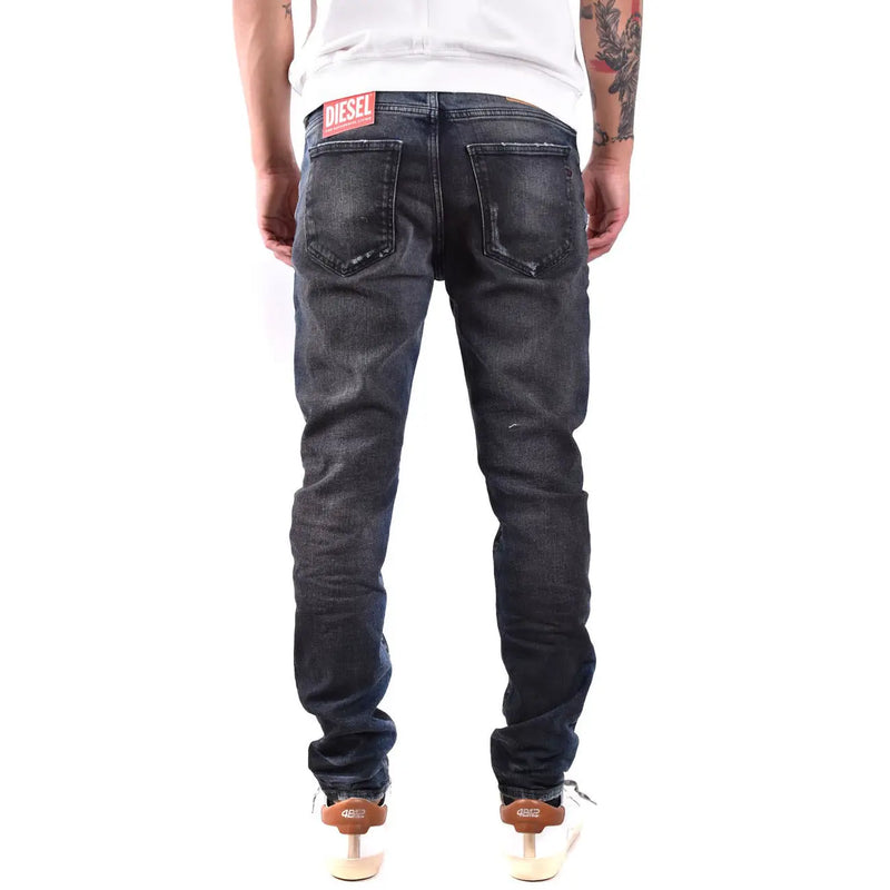 Back side of dark-wash diesel men jeans with blue worn out effect made from 100 cotton featuring distressed look