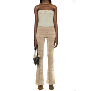 Beige textured knit flare pants styled with diesel women light blue cotton top from spring summer collection