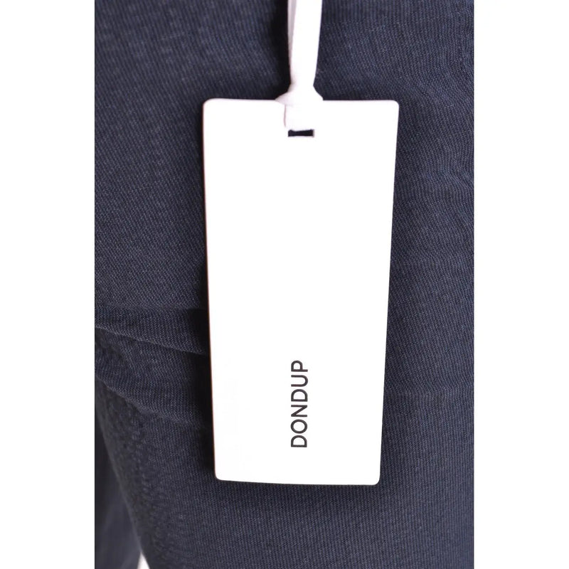 White rectangular dondup brand tag attached to dark navy cotton fabric of men’s spring summer blue trousers
