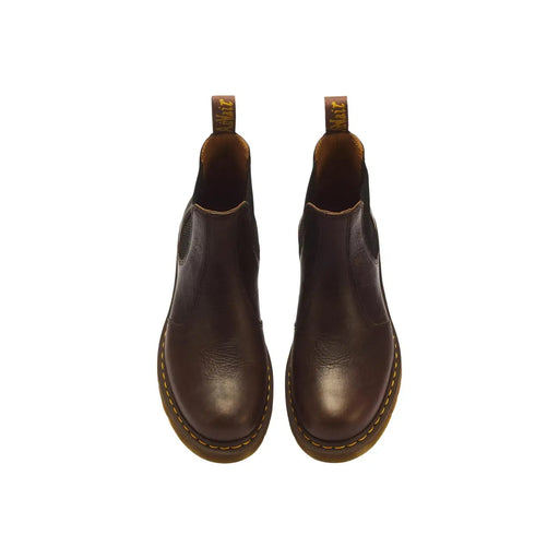 Dark brown leather chelsea boots with yellow stitching and tan rubber soles by dr martens classic 2976 model