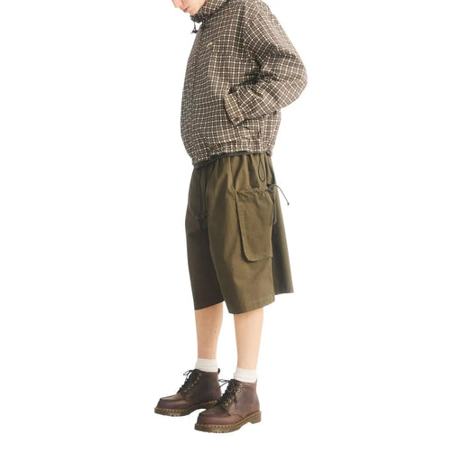Olive green cargo shorts with drawstring waist and pockets shown alongside dr martens men leather chukka boots brown lowell