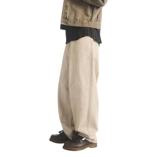 Beige wide-leg denim trousers with relaxed fit and visible stitching paired with brown dr martens men leather moccasin shoes adrian