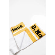 Pair of white athletic socks with yellow stripes and Dr Martens branding for men’s fall winter footwear