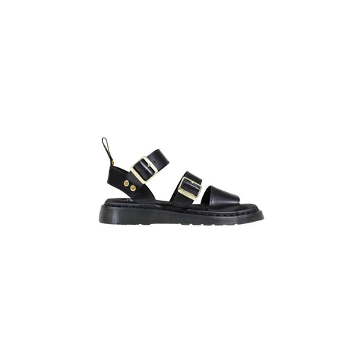 Schwarze Dr. Martens Damen-Sandalen aus Leder mit goldfarbenen Schnallen und einer von hinten sichtbaren, klobigen Gummisohle.