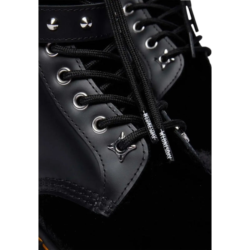 Black leather Dr Martens women boots with black laces featuring silver star aglets and metallic eyelets
