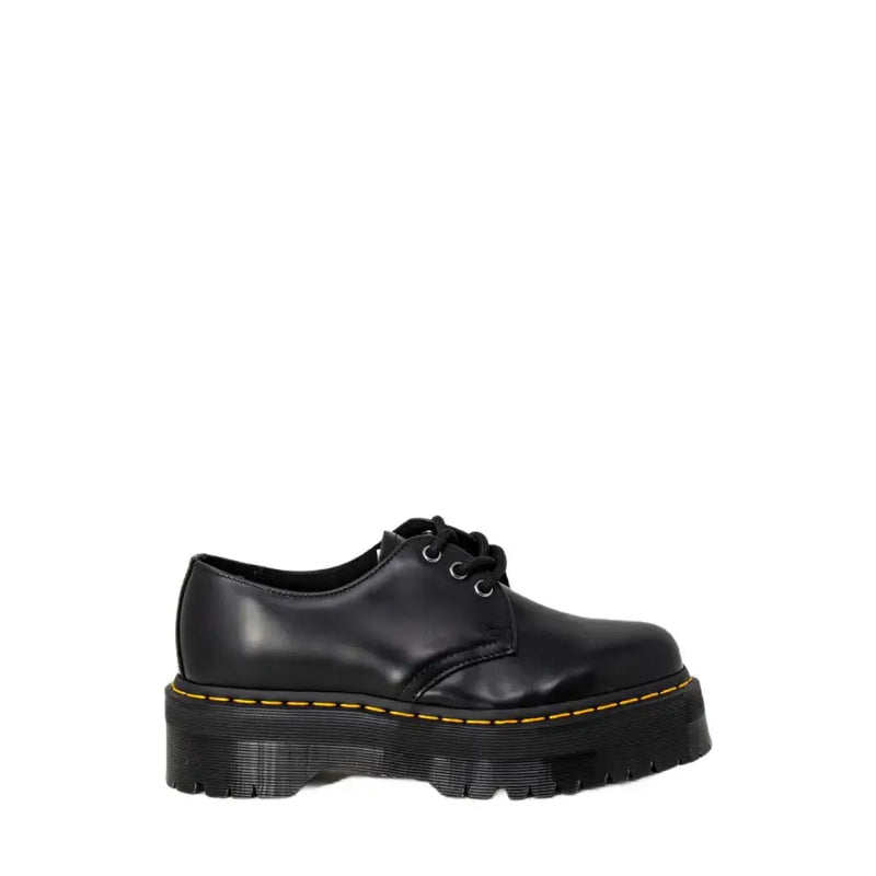 Chaussures Dr Martens pour femmes, en cuir noir, à plateforme, lacets, avec surpiqûres jaunes et semelle épaisse.