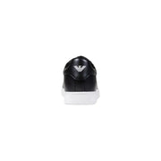 Ea7 Schwarze Herren-Sneaker aus Leder mit weißer Sohle, die die Rückseite freigibt, und silbernem Emporio Armani-Logo an der Ferse.