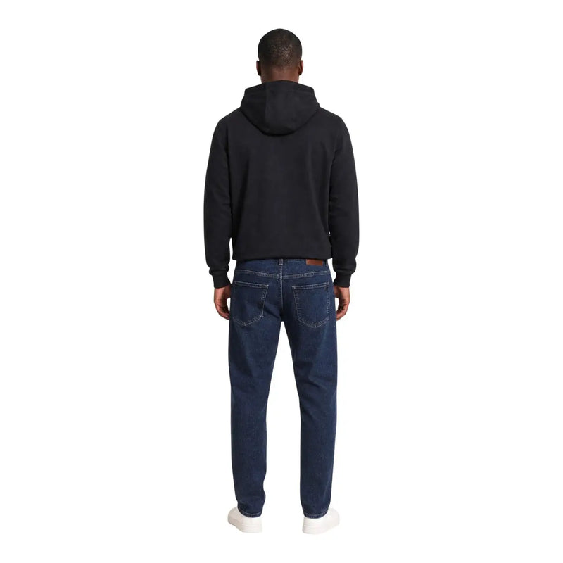 Dunkelblaue Jeans mit klassischem Five-Pocket-Design und dezenter Waschung, kombiniert mit einem schwarzen Baumwoll-Hoodie von ea7 für Herren.