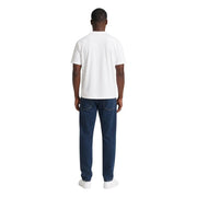 A man wearing an ea7 men white cotton t shirt classic fit with dark blue denim jeans