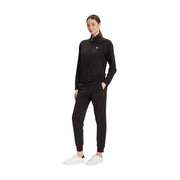 Ea7 Schwarzer Damen-Overall aus Baumwolle mit Rollkragen, kombiniert mit schwarzem Tommy Hilfiger Trainingsanzug mit Reißverschluss und weißen Sneakers.