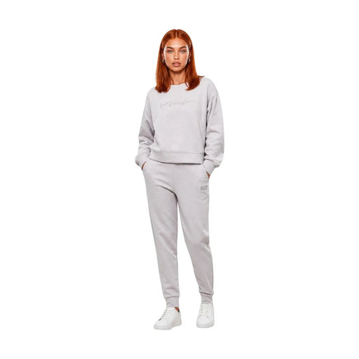 Une femme portant une combinaison en coton gris ea7 pour femme, à col rond, avec un sweat-shirt gris clair et un pantalon de jogging assorti.