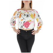 Floral off the shoulder crop top featuring a white blouse with vibrant pink orange and yellow floral print on flowing fabric
