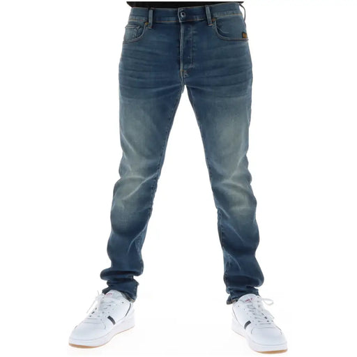 Back side of g-star men jeans 51001 featuring dark-wash slim fit denim with button fly cotton stretch and brown brand patch