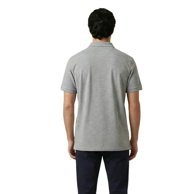 A man wearing a gant men polo shirt grey cotton stretch short sleeve with a classic collar and neatly stitched seams