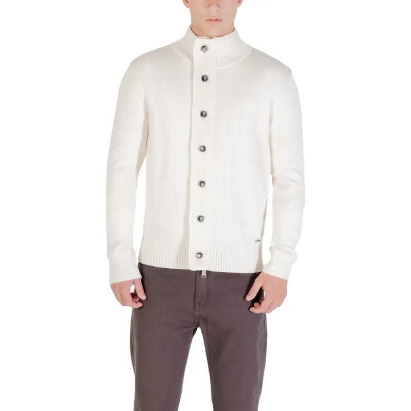 Men’s cream button-up cardigan with mock neck and dark gray buttons paired with brown pants
