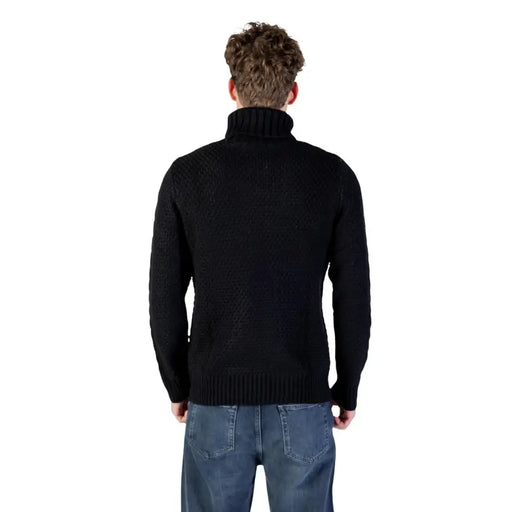 Black turtleneck sweater with ribbed knit design and slim fit.