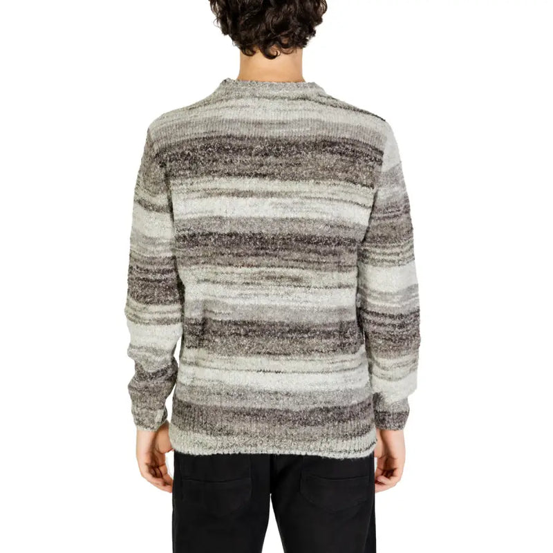 Striped sweater with a mix of gray and black colors, made from soft wool material.