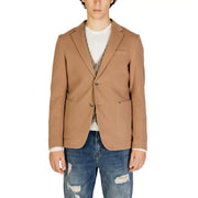 Gianni Lupo Blazer beige en coton pour homme, à deux boutons sur le devant et poches à rabat, porté sur un t-shirt blanc et un gilet à motifs.