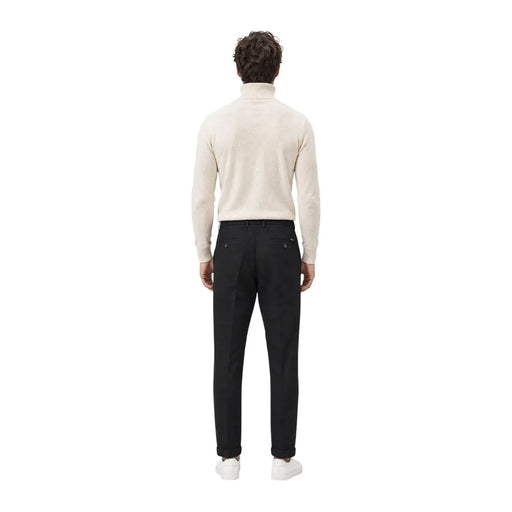 A man wearing gianni lupo men casual black polyester trousers paired with a cream-colored turtleneck sweater