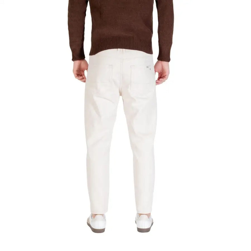 Cream-colored slim-fit denim trousers in white cotton with a clean back pocket design shown from the back by Gianni Lupo
