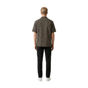 A man wearing a gianni lupo men shirt in dark brown with an intricate gold geometric pattern and short sleeves