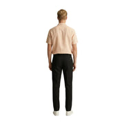 A man wearing a light peach short-sleeved Gianni Lupo men shirt paired with black tailored trousers