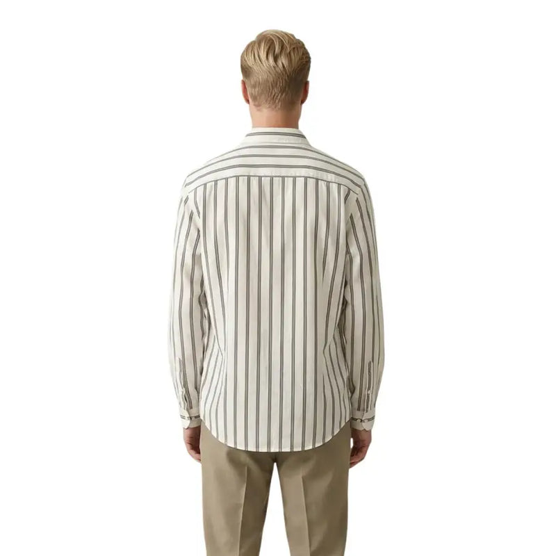 A man wearing a cream-colored long-sleeved Gianni Lupo men shirt with thin vertical charcoal gray stripes