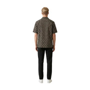 A man wearing a gianni lupo men shirt in dark brown with an intricate gold geometric pattern and short sleeves