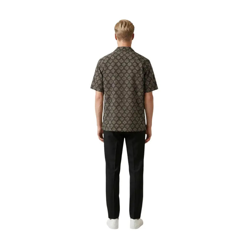 A man wearing a Gianni Lupo men shirt in dark brown with an intricate beige geometric pattern and short sleeves