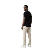 Un homme portant un t-shirt noir à manches courtes Gianni Lupo hommes t-shirt associé à un pantalon beige dans un style décontracté