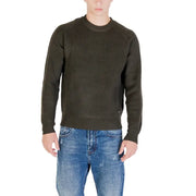 Olive green ribbed sweater with a crew neck and jeans.