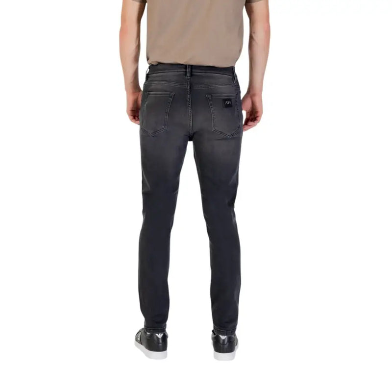 Gray slim-fit jeans paired with black sneakers and a tan T shirt for a stylish look