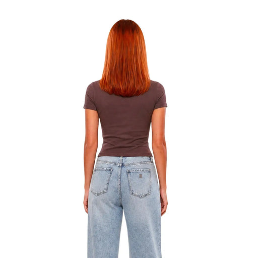 Eine Frau, die eine Guess Active Damen-T-Shirt aus braunem Viskose-Stoff, tailliert, klassisch geschnitten, mit hellen Jeans