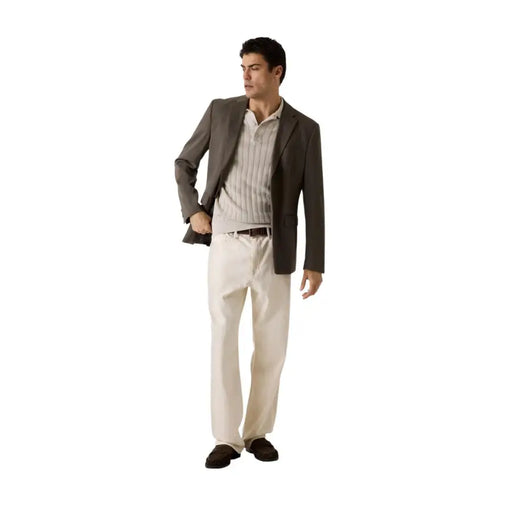 A man wearing a Guess men polo shirt beige short sleeve in cotton viscose paired with a dark gray blazer and cream trousers