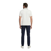 A man wearing a Guess men white short sleeve cotton blend polo shirt with navy trim and dark denim jeans