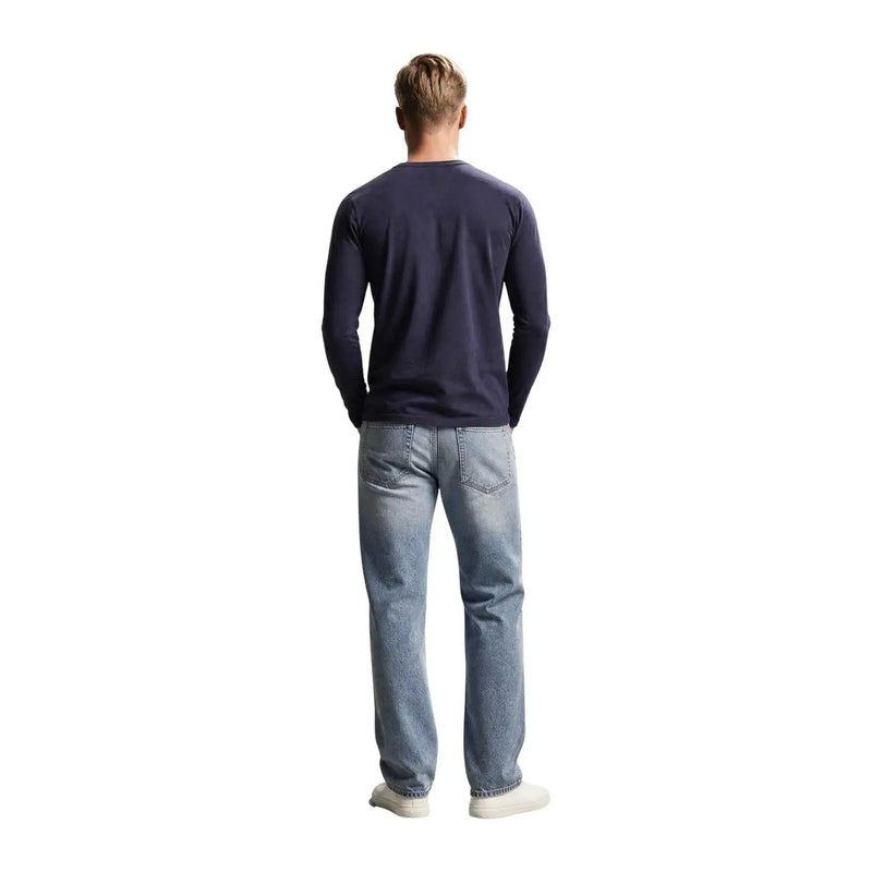 Guess mens navy blue slim fit long-sleeved cotton t shirt paired with light-wash denim jeans in front view