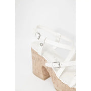 Guess women beige sandals featuring white leather straps, cork wedge heel, and silver buckle details