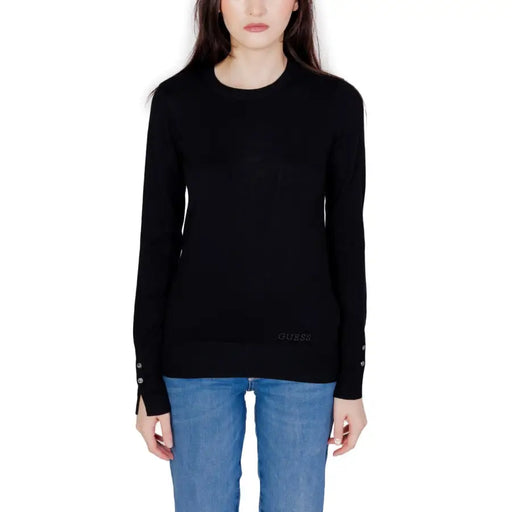 Guess schwarzer, langärmeliger Strickpullover mit Manschettenknöpfen an einem weißen Model