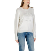 Women wearing Guess long-sleeved cream sweater with blue jeans, featuring a printed design