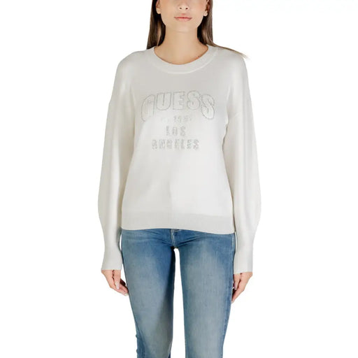Women wearing a white long-sleeve crewneck sweatshirt with blue jeans, stylish casual look