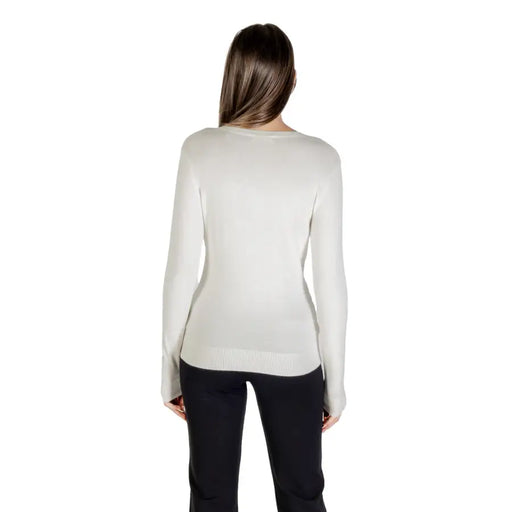 Light grey long-sleeved V neckline sweater with rhinestones worn by a woman facing away