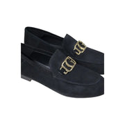 Guess women’s black leather moccasin flats featuring black suede loafers with gold-tone metallic buckles