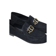 Guess women’s black leather moccasin flats featuring black suede loafers with gold-tone metallic buckles