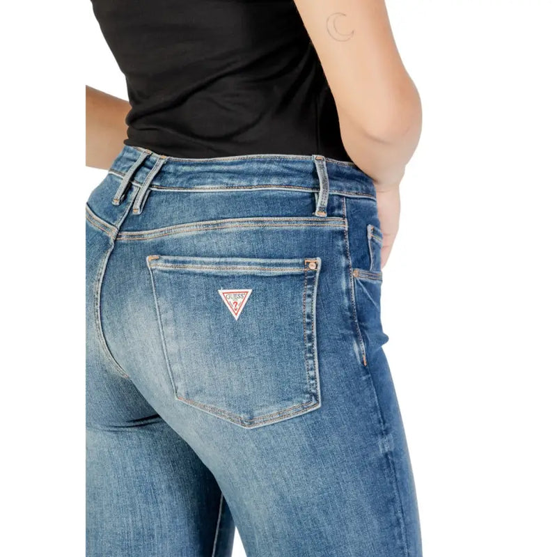Rückseite guess Damen-Jeans aus blauem Denim mit Used-Look und rot-weißem, dreieckigem Logo-Patch auf der Tasche