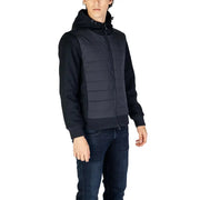 Black quilted hooded vest with ribbed knit sleeves and full-length zipper for men by hydra clothing in fall winter style