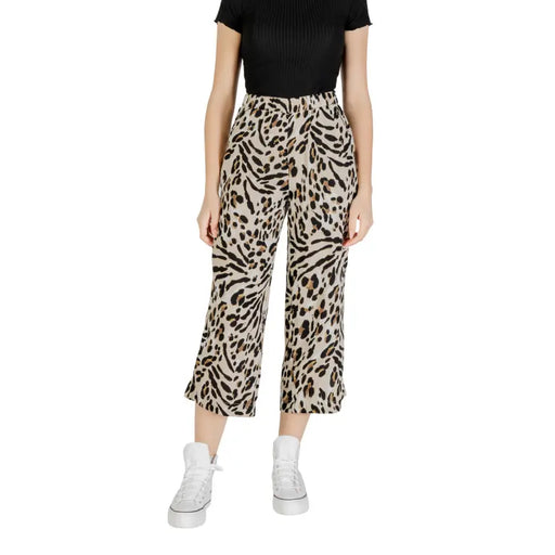 Beige leopard print viscose wide leg cropped trousers paired with a ribbed black top and white platform sneakers
