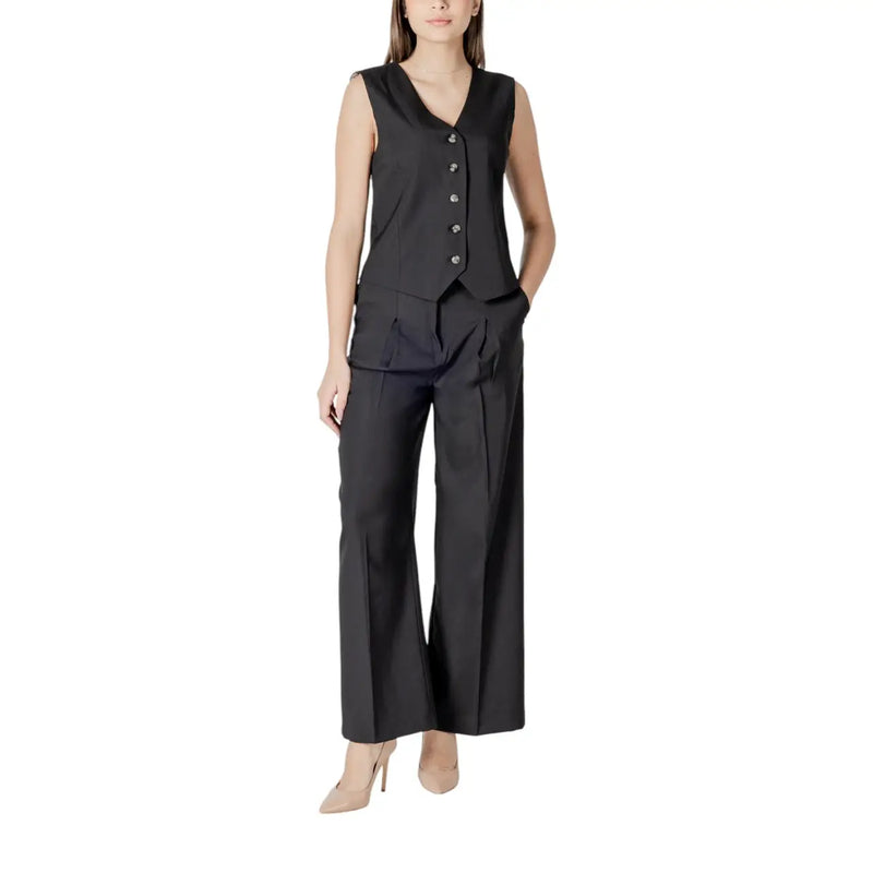 Black sleeveless button-up vest with tailored fit and pleats paired with ichi women black cotton wide-leg trousers with pockets