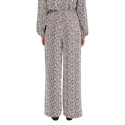 A woman wearing ichi women brown print trousers with a black and white patterned jumpsuit from fall winter collection