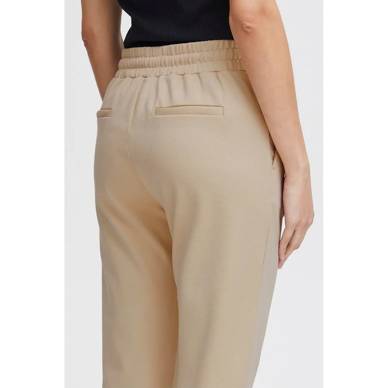 Beige high-waisted ichi women trousers with elastic waistband lace front pockets and two back pockets shown from the back